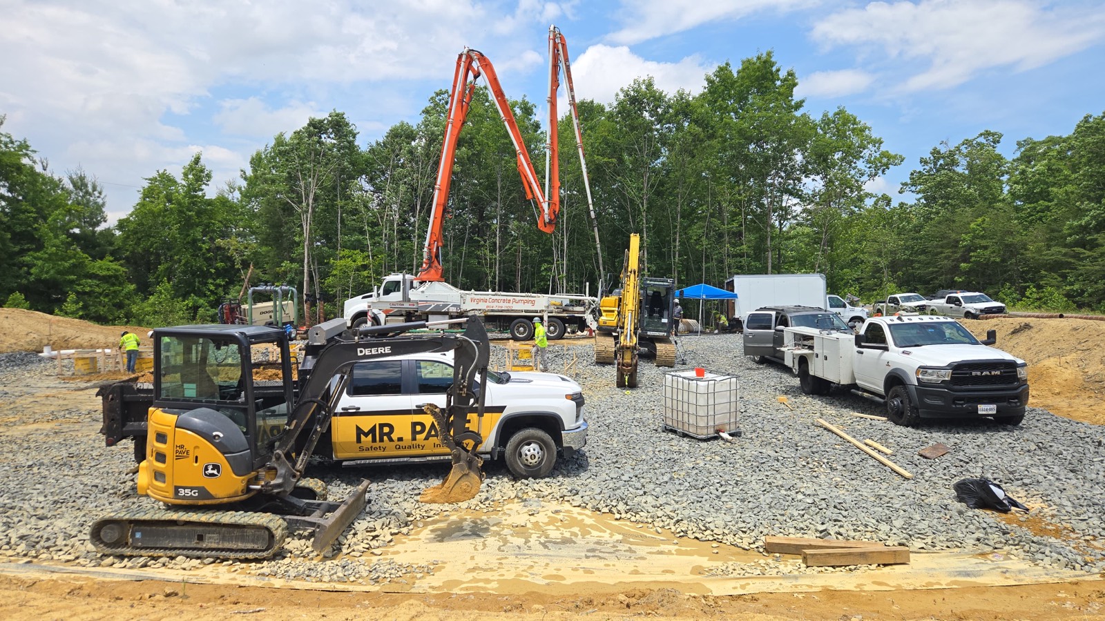 Mr. Pave branded mini-excavator and dump truck positioned for a foundation dig
