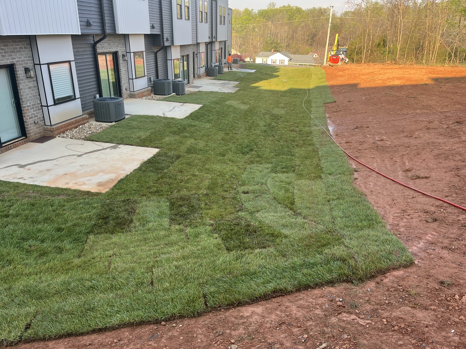 Sod installation crew finishing the lawn at a new townhome development