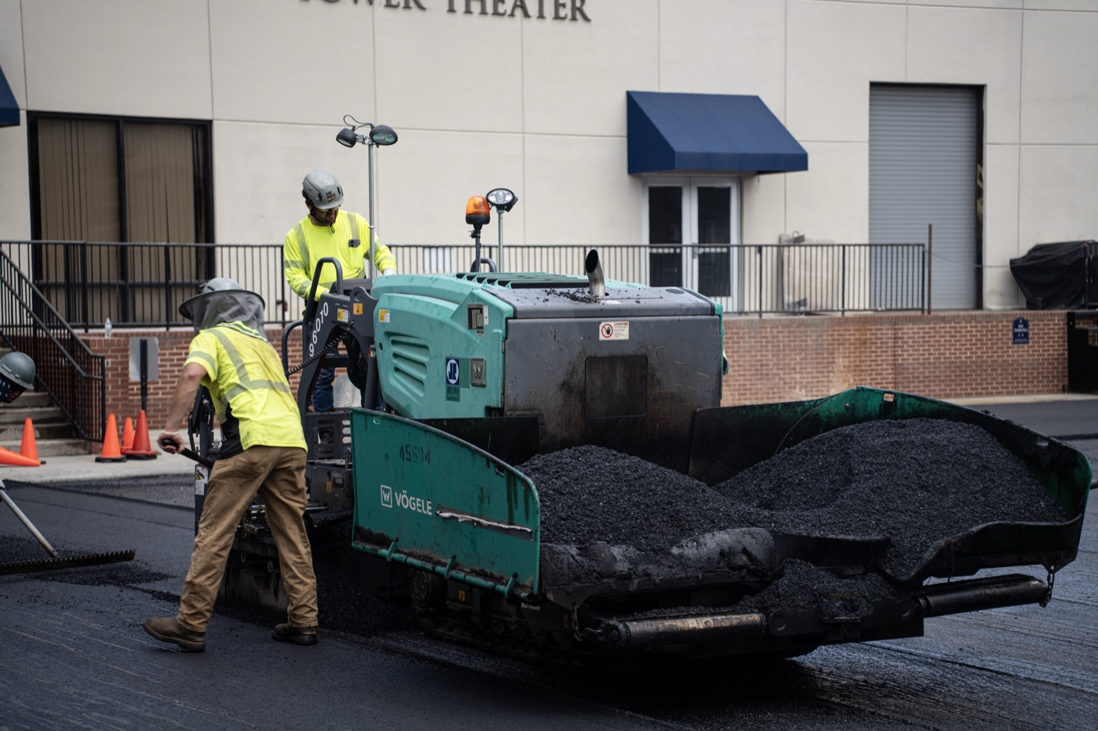Vögele asphalt paver laying fresh blacktop outside a commercial building